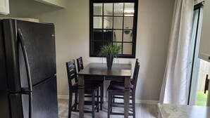A kitchen with a black refrigerator, wooden dining table, and chairs. - Beautiful 3 Bed, 2 Bath, Sleeps 6, Full Kitchen. garage. Close to World cup! (Lee's Summit)