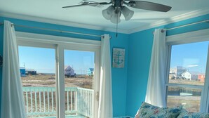 A bedroom with a bed, a ceiling fan, and a view of the beach through large windows. - Gulf and Bay Views in Fort Morgan! Short walk to beach. Room to park the boat! (Gulf Shores)