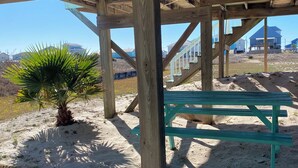 A wooden structure with a bench and palm tree, under a clear sky. - Gulf and Bay Views in Fort Morgan! Short walk to beach. Room to park the boat! (Gulf Shores)
