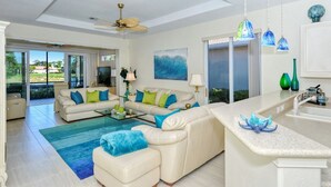 Un salón amplio con un sofá grande, una mesa de centro y vistas al exterior.