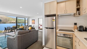 Una cocina moderna con electrodomésticos de acero inoxidable, armarios de madera y vistas a un lago.