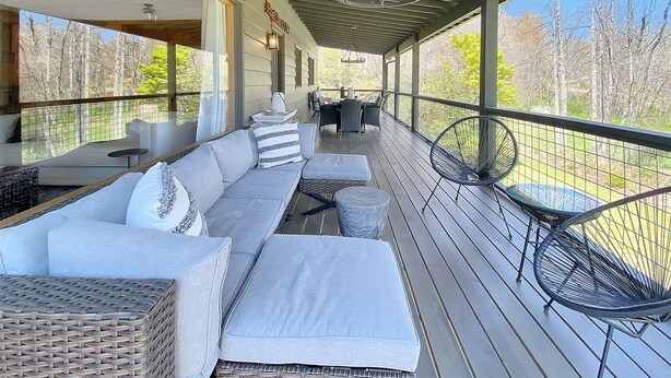 A covered outdoor seating area with a sofa, chairs, and a table. - The Kind of Place You Stop Rushing the Moment You Arrive | Bungalow on Crowe (Highlands)