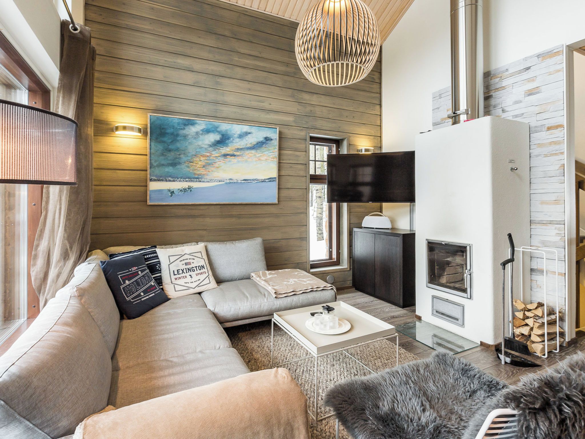 Un salon moderne avec un canapé, une table basse, une cheminée et un tableau accroché au mur.