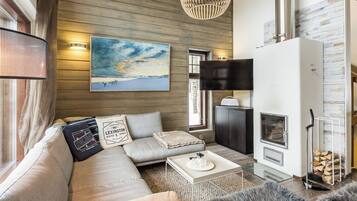 Una sala de estar moderna con sofá, una mesa de centro, chimenea y un cuadro en la pared.