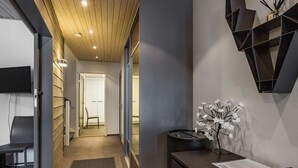 Un espace d’accueil moderne comprenant un bureau, une chaise, une étagère fixée au mur et une porte donnant sur une autre pièce.