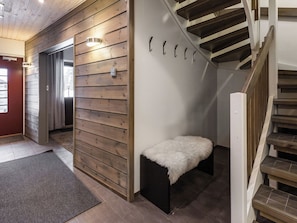 Een modern interieur met een houten wand, een bank met een zachte hoes en een trap.