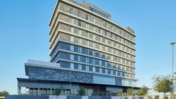 A multi-story hotel with a modern design, featuring a prominent entrance with large windows and a flat roof.