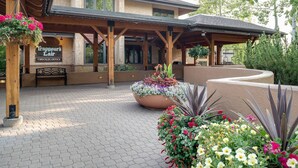 Een hotelentree met een overdekt terras, receptie en bloemdecoraties.