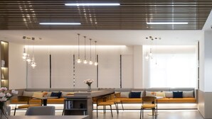 Un interior moderno con una mesa larga para comer, un sofá y una zona de cocina.