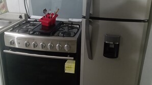 Eine Küche mit Gasherd, Backofen und einem Edelstahl-Kühlschrank.