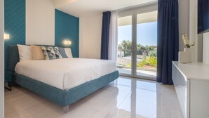 Un dormitorio moderno con cama, mesita de noche, cómoda y balcón con cortinas.