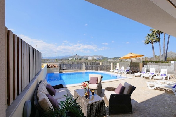 A pool area with lounge chairs, a sofa, and a table with drinks. - "Villa Jerónimo" with Mountain Views, Wi-Fi, Pool, Garden, Terrace & Balcony (Muro)