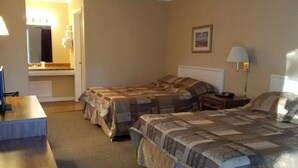 A hotel room with two beds, a desk, a mirror, and a bathroom visible through an open door. - Unity Lodge Suite 7 (Golconda)