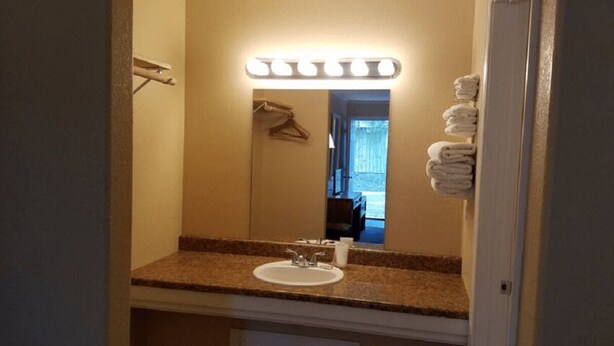 A bathroom with a sink, mirror, and towel rack. - Unity Lodge Suite 7 (Golconda)