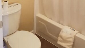 A bathroom with a toilet, a bathtub, and a shower curtain. - Unity Lodge Suite 7 (Golconda)