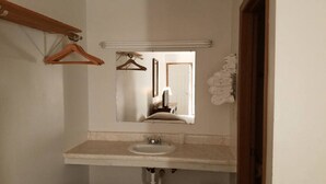 A bathroom with a sink, mirror, and wooden hanger. - Unity Lodge Suite 9 (Golconda)