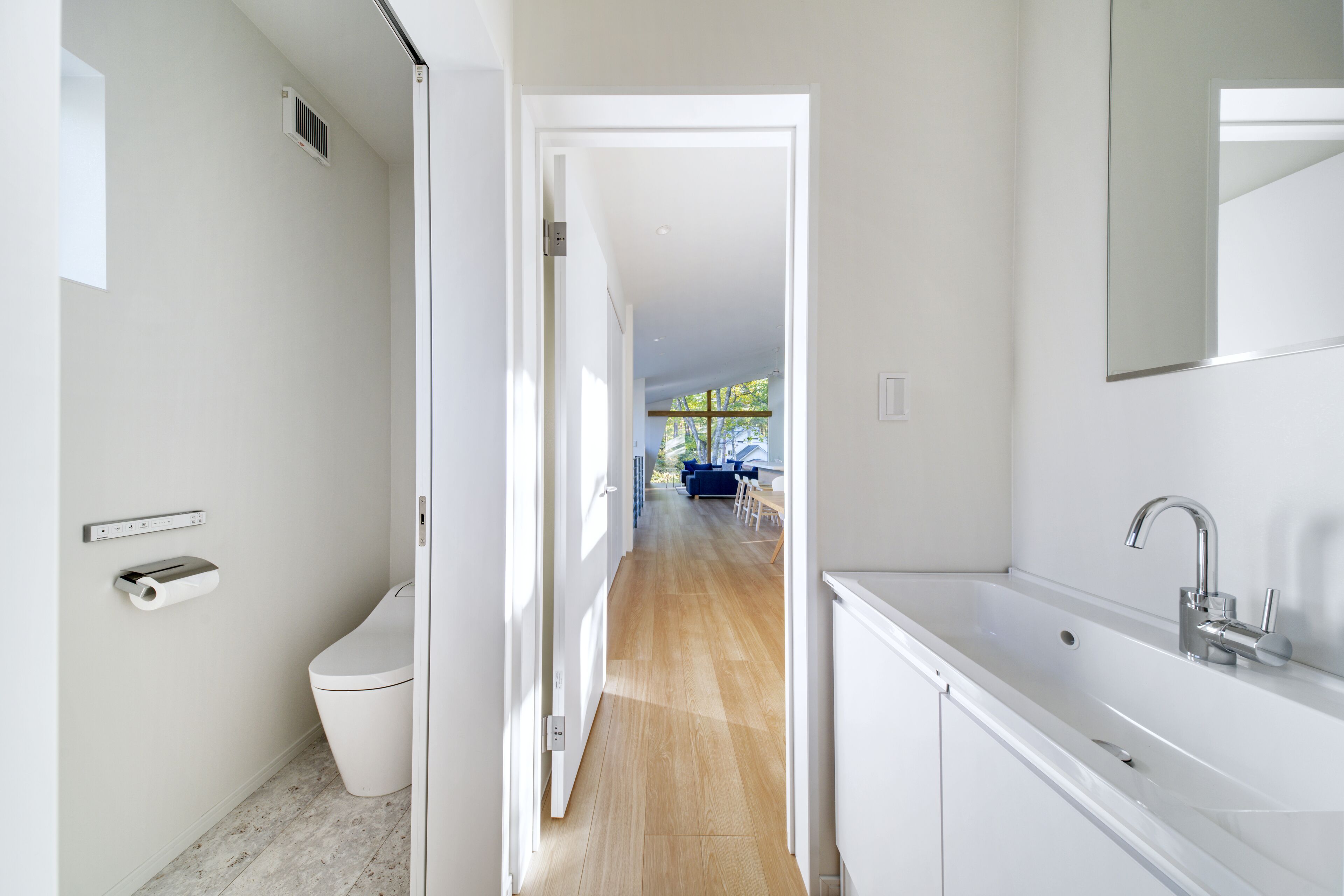 A modern bathroom with a toilet, a sink, and a mirror.