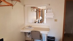Une salle de bain avec un lavabo blanc, un miroir et un porte-serviettes.