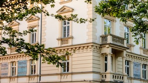 A historic building with multiple windows and balconies, featuring signs for a hotel, restaurant, and spa. - MR67 Mayera Rapaporta  (Kraków)