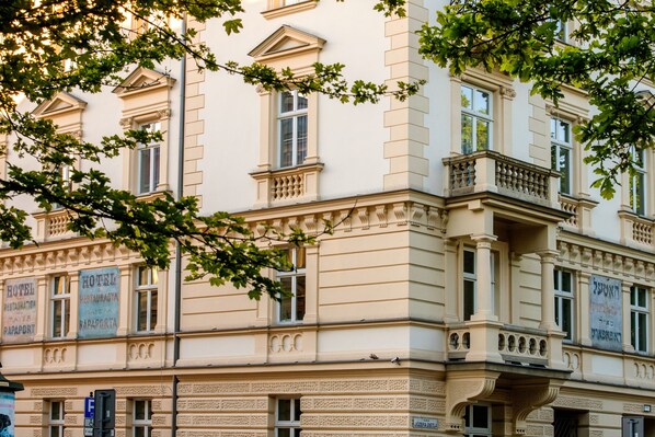 A historic building with multiple windows and balconies, featuring signs for a hotel, restaurant, and spa. - MR67 Mayera Rapaporta (Kraków)