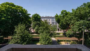A view of a building with a symmetrical facade, surrounded by lush greenery and a well-maintained garden. - MR67 Mayera Rapaporta  (Kraków)