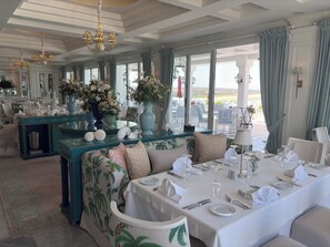 Comedor con una mesa lista para comer, ventanas amplias y vistas al exterior.