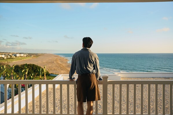A person standing on a balcony overlooking a beach with a clear sky. - Le Mirage Tanger (Tangier)