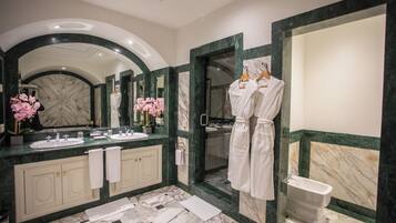 Un baño moderno con un espejo grande, dos lavamanos, una bañera y zona de ducha.
