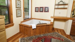 A bathroom with a wooden bathtub, a window, and a wooden floor. - The Bird Hallar - Cozy, quiet cabin in The Glades! (Gatlinburg)