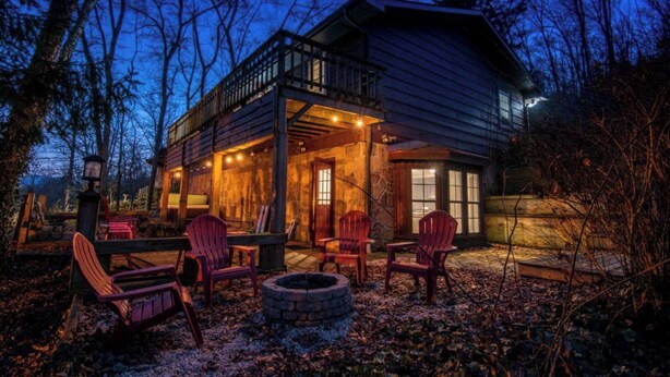 A wooden cabin with a balcony, outdoor seating, and a fire pit. - Whiskey Ridge - Pet-friendly, Game Tables ,Wi-Fi, Firepit, Rocking Chairs (Sevierville)