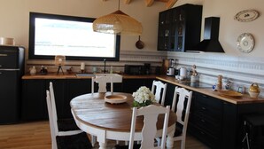 Una cucina moderna con un tavolo da pranzo in legno, sedie bianche e pensili neri.