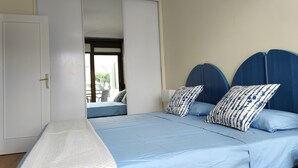 A bedroom with a bed, a wardrobe, and a view through an open door. - Best Location. Playa Las Vistas. Free Wifi (Playa de la Américas)