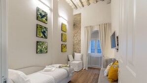 A bedroom with a bed, a bedside table, a window with curtains, and artwork on the wall. - " PALAZZO OF LORDS " LUXURY & DESIGN LOFT/APT WITH VIEW, FLORENCE (Firenze)