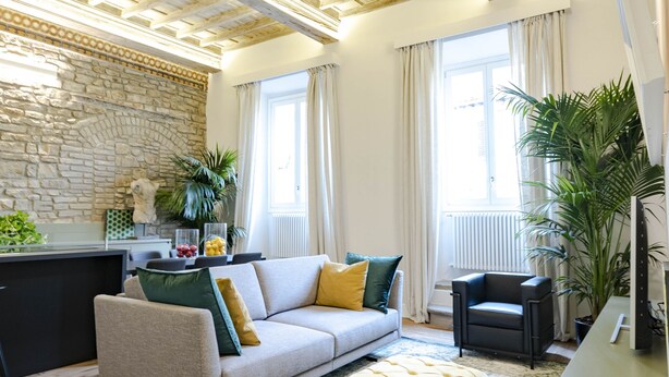 A modern living room with a sofa, ottoman, and a desk area. - " PALAZZO OF LORDS " LUXURY & DESIGN LOFT/APT WITH VIEW, FLORENCE (Firenze)