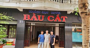 La entrada del hotel Khach San Báu Cát con un letrero grande sobre la puerta.