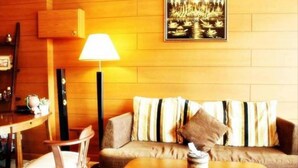 Uma sala de estar aconchegante com um sofá, uma mesa de centro e uma luminária.