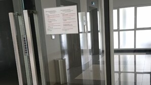 A modern elevator interior with a glass door, a metal handrail, and a digital display. - Sultan Premiere Casa De Parco (Pagedangan)