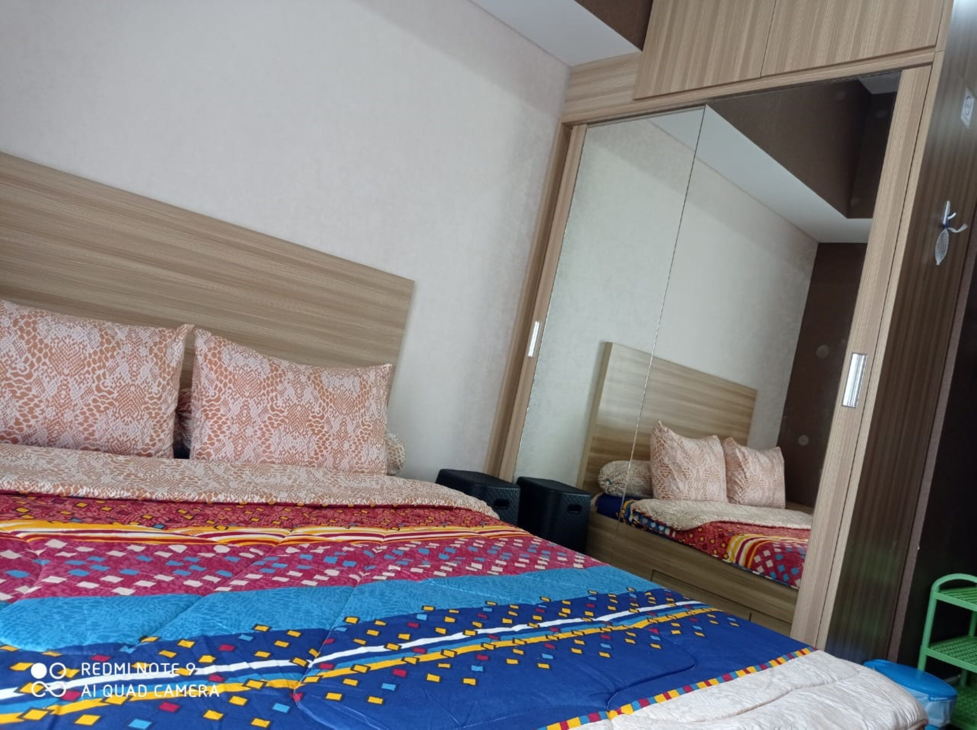 Une chambre à coucher avec un lit, une armoire et un miroir.