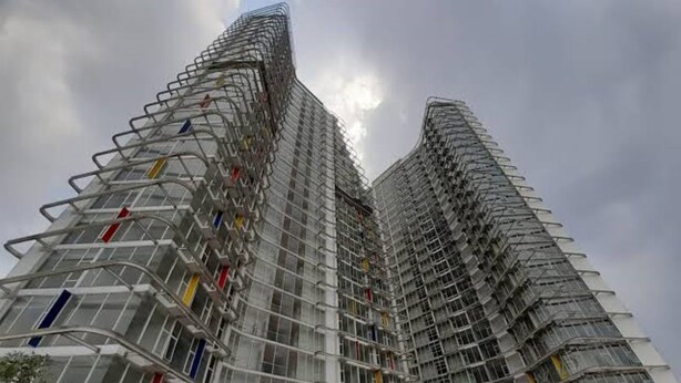 A modern high-rise building with a unique curved facade and multiple balconies. - Sultan Premiere HI (South Tangerang)