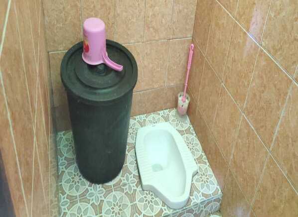 A bathroom with a toilet, a trash bin, and a toilet brush. - Winahyu Family Resort (Wonosari)
