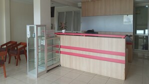 Una cucina moderna con mobili in legno, frigorifero con vetrina e una piccola isola con piano rosa.