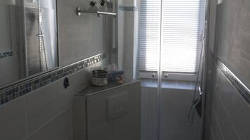 A bathroom with a shower, toilet, and sink.