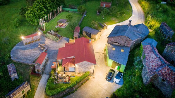 A residential area with multiple houses, a paved driveway, and a small garden area with outdoor seating. - Casa da Loura - Costa da Morte (A Coruna)