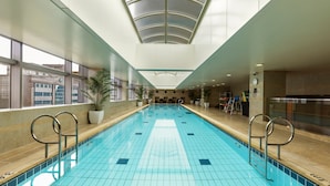 A large indoor swimming pool with clear blue tiles, metal handrails, and potted plants along the sides. - Hotel Metropolitan Premier Taipei (Taipei)