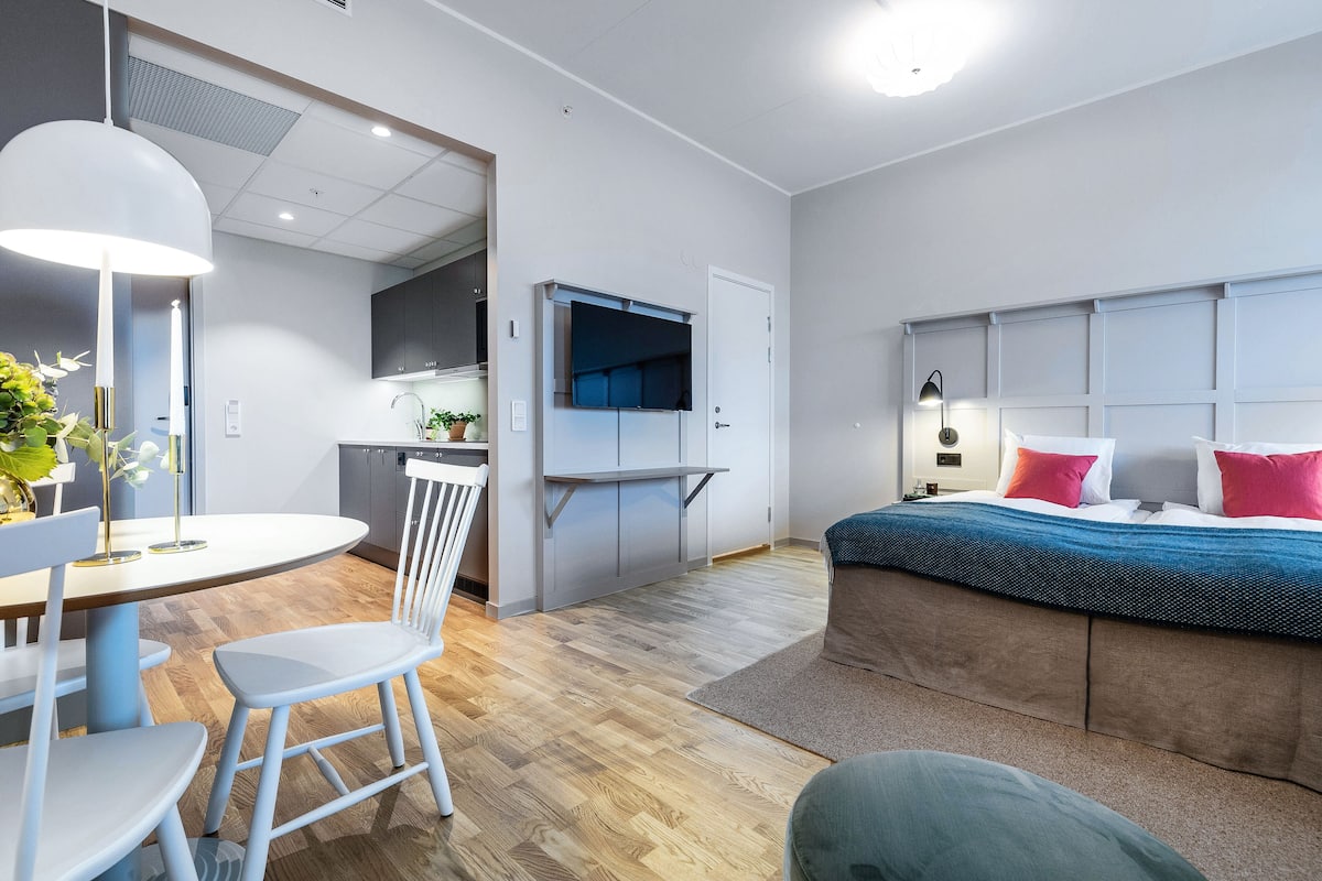 Un dormitorio moderno con una cama grande, un escritorio y una silla.