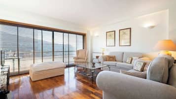 Un salón amplio con un ventanal grande, un conjunto de sofá, una mesa de centro y un sillón.