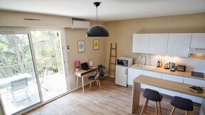 Una cocina moderna con comedor, un refrigerador pequeño y un microondas.