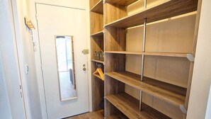 Un vestidor con estantes de madera y un espejo.