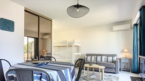 A modern living room with a dining area, a sofa, and a bunk bed. - (029) L'entre deux à 4 (Antibes)