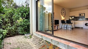 A modern kitchen with a large window, a clock, and a washing machine.